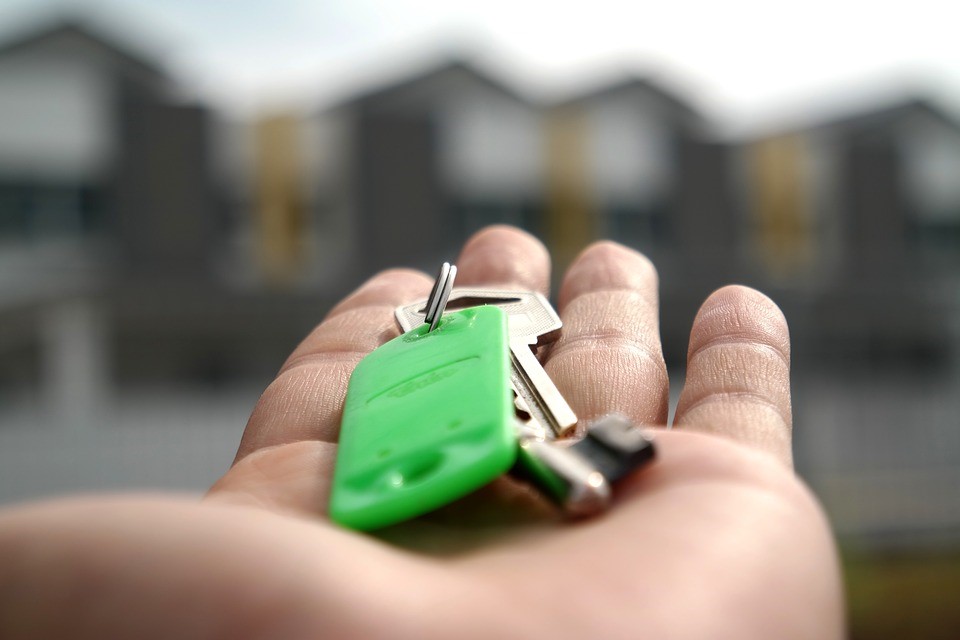 person holding green house keys in their palm