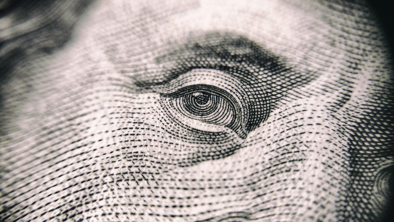 a close up of Benjamin Franklin’s eye on a $100 bill