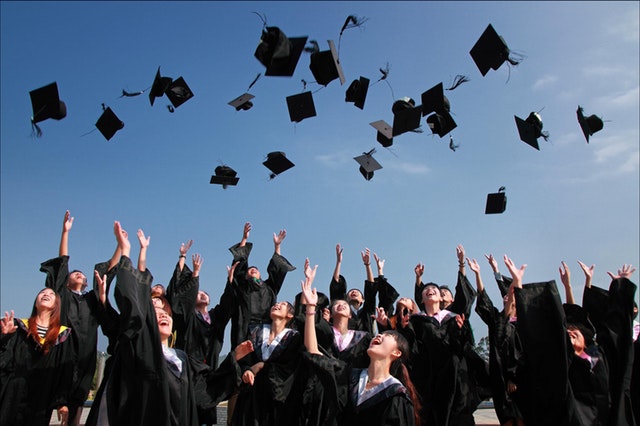 graduating college students throwing hats in the air