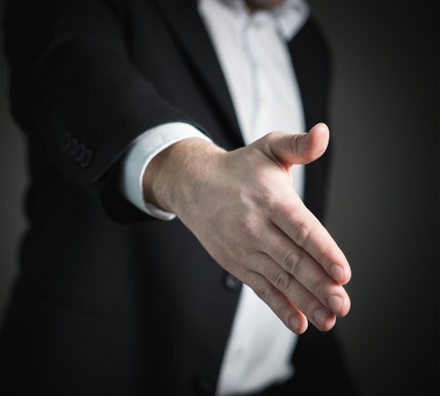 Person in suit with their hand outstretched
