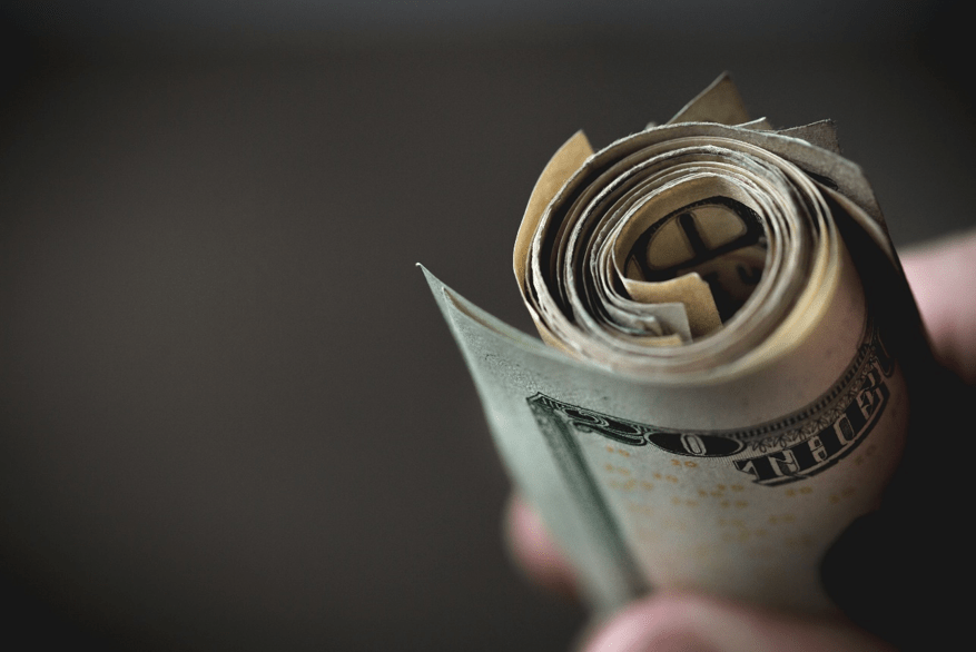 selective focus of American dollar bills rolled up into a spiral